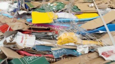 A large stack of waste paper from pressed cardboard boxes is sorted and packed for paper recycling. Sorting garbage. Secondary use of resources. Raw materials for the pulp industry.