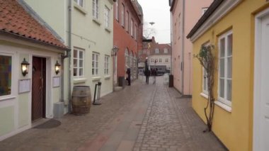 Danimarka 'nın eski kenti Odense' nin merkezindeki kaldırımlı rahat caddelerde eski moda kırmızı tuğlalı evler..