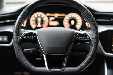 Modern bir arabanın direksiyonunda seyir kontrolü ve telefon düğmeleri. Araba kontrol paneli kapanıyor. Sığ alan derinliği, bulanık arkaplan