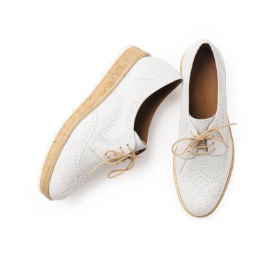 Beyaz bağcıklı ve mantar tabanlı gündelik beyaz deri ayakkabılar. Beyaz arka planda yeni kadın ayakkabıları.