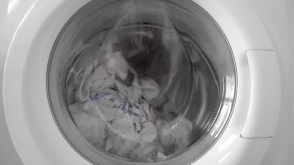 洗濯または洗浄中のホワイトリネンは 家庭用洗濯機のドラムで回転します — ストック動画