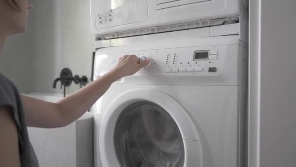 女人打开家用洗衣机 选择洗衣服的自行车 然后开始洗衣服 — 图库视频影像