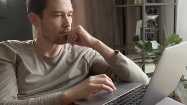 Ein Mann Arbeitet Einem Laptop Und Sitzt Hause Auf Der — Stockvideo
