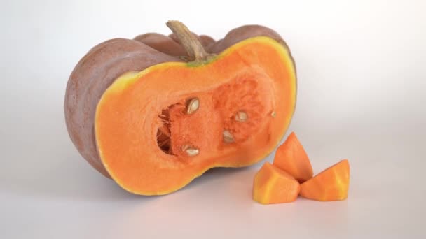 Polovina Zralého Pomerančového Dýně Vedle Rozprostřené Dýňové Dužniny Bílém Pozadí — Stock video