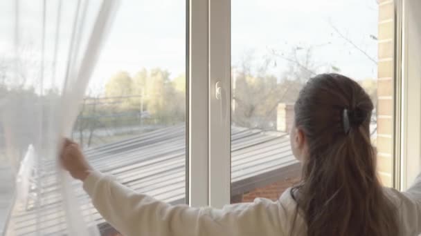 女人拉开透明的郁金香窗帘 转动聚氯乙烯塑料窗框上的把手 打开窗户 通风房间 — 图库视频影像