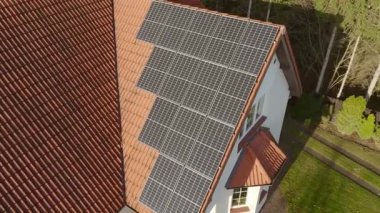 Güneş ışığını elektriğe çevirmede yüksek verimliliğe sahip katı silikon kristalden yapılmış modern fotovoltaik güneş panelleri özel bir evin kiremitli çatısına kurulmuştur..