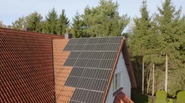 Fotovoltaik güneş panelleri özel bir evin kiremitli çatısına monte edildi. Özel evlerin elektriklenmesi için güneş enerjisiyle çalışan bir ev enerjisi sistemi..