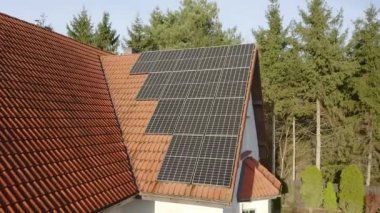 Fotovoltaik güneş hücreleri özel bir evin kiremitli çatısına yerleştirildi. Özel evlerin elektriklenmesi için güneş enerjisiyle çalışan bir ev enerjisi sistemi..