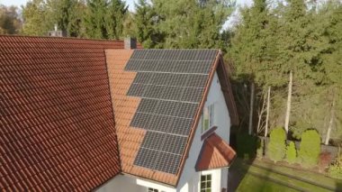Fotovoltaik güneş pilleri bir evin fayanslı çatısında güneş enerjisinden elektrik üretmek için kullanılır. Yenilenebilir enerji kaynaklarından enerji tedarik etmek için ekipman. Özel evlerde yeşil enerji.