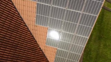 Evin çatısında güneş enerjisinden elektrik üretmek için fotovoltaik güneş panellerinin yüzeyinde güneş parlaması. Yenilenebilir enerji kaynaklarından enerji tedariği için ekipman.