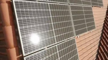 Evin çatısında güneş enerjisinden elektrik üretmek için fotovoltaik güneş modüllerinin yüzeyinde güneş parlaması. Yenilenebilir enerji kaynaklarından enerji tedariği için ekipman.