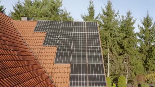 太陽エネルギーから発電するための太陽光発電モジュールは家の傾斜した屋根にあります 再生可能エネルギー源からのエネルギー供給のための設備 プライベートハウスにおけるグリーンエネルギー — ストック動画