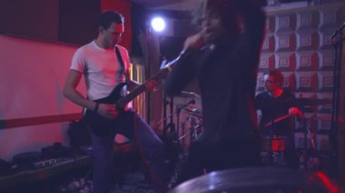 Heavy metal grubunun vokalisti küçük bir prova odasındaki bir provada müziğin ritmine kafa sallıyor. Grubun solisti şarkıyı söylerken duygusal olarak başını sallıyor..
