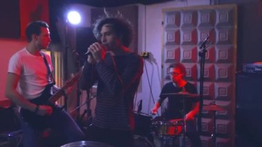 Çocuklar enstrüman çalar ve şarkı söylerler. Gitarist elektro gitar çalar, davulcu davul ve zilleri çalar ve vokalist mikrofona şarkı söyler.,