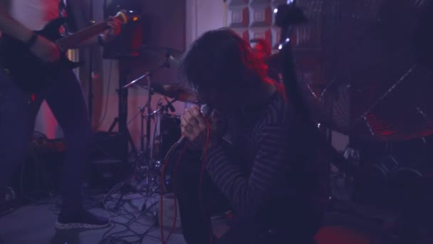 Der Leadsänger Der Rockband Singt Leidenschaftlich Kniend Auf Dem Boden — Stockvideo