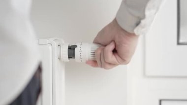 Adam termostat vanasını sıfıra eşit olan en düşük değere çeviriyor ve ısıtma kaloriferini tamamen kapatıyor ve odanın içine temiz hava girmesi için pencereyi hafifçe açıyor..