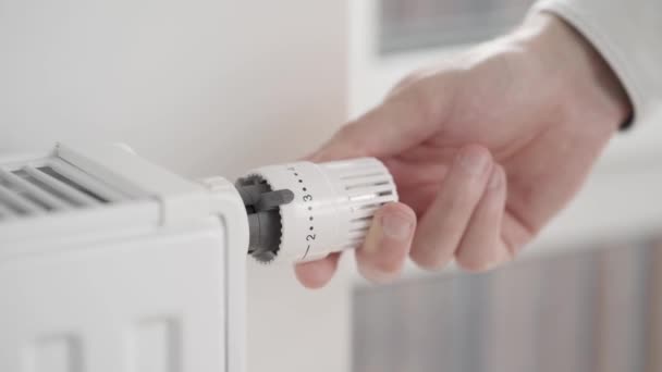 Man Vermindert Het Verwarmingsvermogen Van Het Huis Van Maximale Waarde — Stockvideo