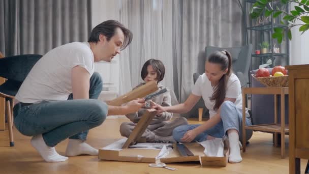 Γονείς Και Ένα Παιδί Κάθονται Στο Πάτωμα Στο Σπίτι Και — Αρχείο Βίντεο