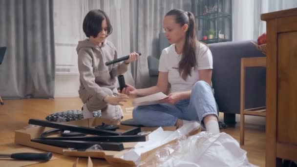 Anne Oğlu Yerde Yatan Parçalardan Bir Sandalye Yapmak Için Birlikte — Stok video