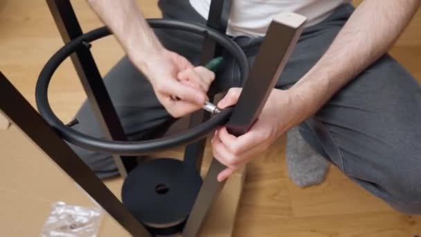 Człowiek Ręcznie Dokręca Śruby Śrubokrętem Zapadkowym Montując Nowe Krzesło Zestawu — Wideo stockowe