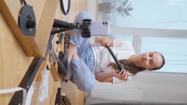 바닥에 앉아있는 소녀는 삼각대에 스마트 카메라의 집에서 지시에 세트에서 사항을 — 비디오
