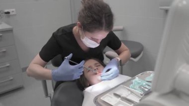 Bebek dişini çıkarmadan önce içine şırınga ile sızma anestezisi enjekte edilmiş. Diş hekimi, diş tedavisinden önce çocuğa anestezi yapar..