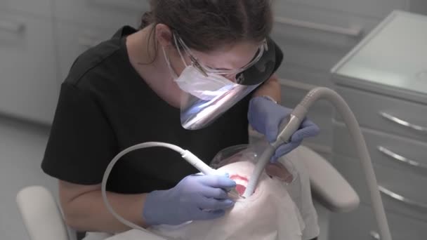 의사는 질환을 예방하는 도움이되는 장치를 사용하여 환자의 치아를 플라크와 타타르에서 — 비디오