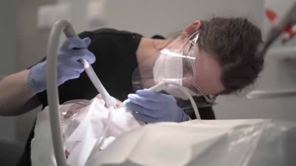 Μια Γυναίκα Οδοντίατρος Εκτελεί Μια Οδοντιατρική Διαδικασία Για Μια Ασθενή — Αρχείο Βίντεο