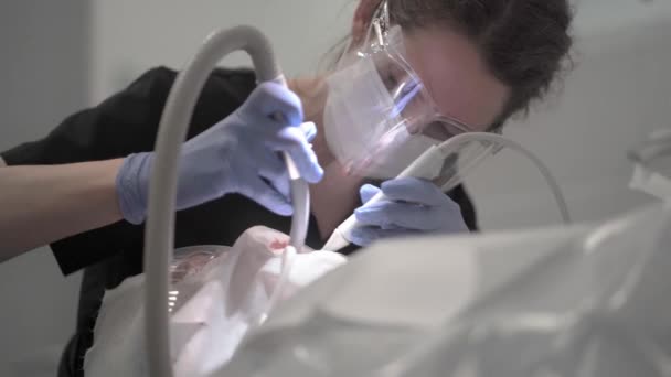 Ένας Οδοντίατρος Προστατευτική Μάσκα Έχει Εργαλεία Οδοντιατρικής Θεραπείας Στα Χέρια — Αρχείο Βίντεο