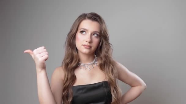 메이크업 스파게티 스트랩 드레스에 머리와 정신적으로 배경에 스튜디오에서 그녀의 손가락에 — 비디오