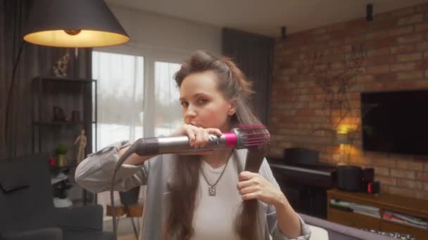 Μια Γυναίκα Χτενίζει Μαλλιά Της Ένα Στεγνωτήρα Μαλλιών Χρησιμοποιώντας Ένα — Αρχείο Βίντεο