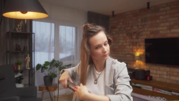 Μια Γυναίκα Κουρνιάζει Ένα Εξάρτημα Βούρτσας Χρησιμοποιώντας Ένα Στεγνωτήρα Μαλλιών — Αρχείο Βίντεο