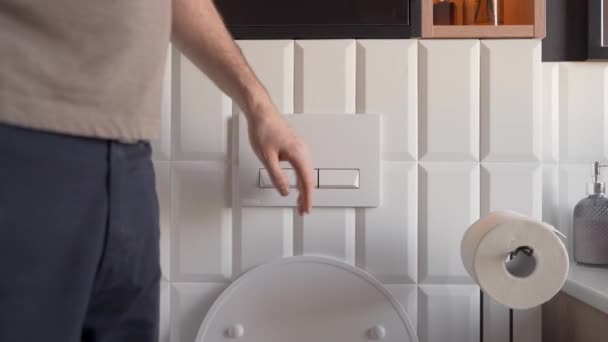 出于对节约用水的担忧 这位男士按下了环保马桶的按钮 进行了低流量冲水 经济的冲洗机制 有助维持清洁和卫生的厕所环境 — 图库视频影像