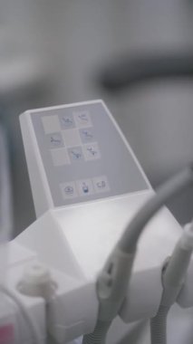 Kontrol panelindeki düğmeler dişçi koltuğunun arkasını diş işçiliği için değiştiriyor. Diş sağlığı kliniği için tıbbi ekipman.