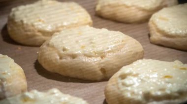 Ev yapımı süzme peynirli tatlı çörekler (vatrushka) sıcak fırında pişirilir. Çiğ hamur hamuru ile süzme peynirli çörek pişirme zamanı. Ev yapımı pişirme işlemi.