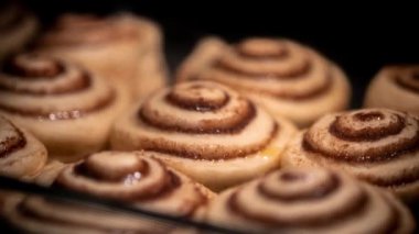 Fırında ev yapımı tatlı rulo pişirme zamanı. Geleneksel Amerikan dürümleri tarçın ve şeker ile doldurulmuş maya hamuru, krem peynir, pudra şekeri ve vanilya.