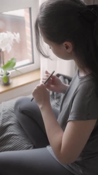 Молода Жінка Дає Собі Французький Манікюр Сидячи Ліжку Біля Вікна — стокове відео