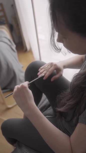 Een Jong Meisje Vijlt Natuurlijke Nagels Met Een Nagelvijl Zittend — Stockvideo