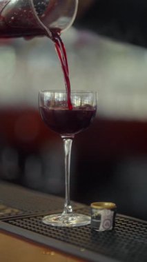 Barmen buzları ayırmak için meyve suyu süzgecinden soğuk bir alkollü kokteyli bardağa doldurur. Kokteyl cama güzel bir akarsu gibi akıyor. Bardağa bir damla düşer..