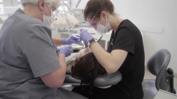 Caries Behandeling Een Tandheelkundige Kliniek Een Tandartsassistent Helpt Dokter Teamwerk — Stockvideo