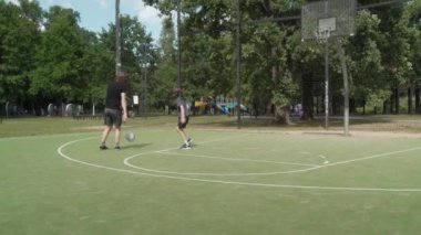 İki kardeş dışarıda basketbol oynuyor. Büyük kardeş küçüklere top sürmede ve defansta yardım ediyor, yakın ilişkilerini, takım çalışmalarını ve aktif oyun oynamanın keyfini vurguluyor..