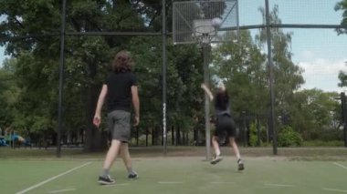 İki arkadaş basketbol antrenmanı yapıyor, takım çalışması ve arkadaşlık gösteriyor. Oyuncular basket, kaygısız oyun ve gençlik arkadaşlığını paylaşarak şut attılar. Egzersiz, işbirliği ve spor..