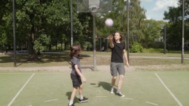 Basketbol sahasında iki adam basket atıyor, potaya girmeye çalışıyorlar. Top potayı ıskaladı, çembere ya da arka tahtaya çarptı. Iskalamalarına rağmen ateş etmeye devam ediyorlar..