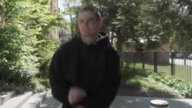 Kapüşonlu genç bir adam güneşli bir sokakta özgürce dans ediyor, pozitif enerji ve neşe saçıyor. Kaygısız tavrı, düzgün hareketleri ve kendine güveni neşeyi, özgürlüğü ve kendini ifade edişini yansıtıyor..