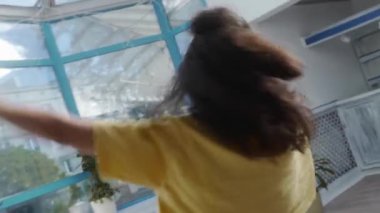 Kadın dans ederek dönüyor. Dansçının kolları pürüzsüz, akışkan hareketlerle hareket eder. Enerjik dans özgürlüğü ve kendini ifade etmeyi gösterir. Hareketler değişkendir, özgürlük ve doğallık hissini yakalar..