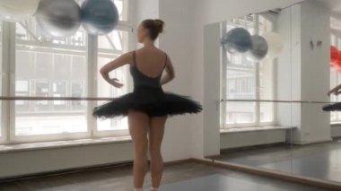 Balerin etekli ve sivri uçlu ayakkabılı. Dönme dolap, dönme dolap ve fouette çalışıyor. Dans sınıfındaki bir dansçı bale yeteneklerini geliştirir. Bale stüdyosunun koridorunda zarifçe ilerler..