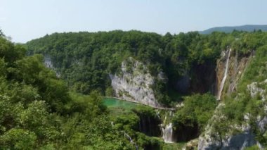 Plitvice Gölleri 'ndeki kayalıklar ve şelaleler boyunca popüler yürüyüş patikalarının panoraması. Plitvice Lakes Ulusal Parkı, UNESCO 'nun Dünya Mirasları Listesine dahil olmak üzere Hırvatistan' da bir turizm merkezi..
