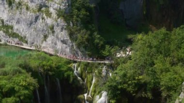 Plitvice Gölleri 'ndeki kayalıklar ve şelaleler boyunca popüler yürüyüş patikalarının panoraması. Plitvice Lakes Ulusal Parkı, UNESCO 'nun Dünya Mirasları Listesine dahil olmak üzere Hırvatistan' da bir turizm merkezi..