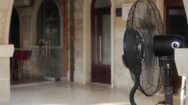 Açık kafe ve restoranların terasları için nemlendirici bir vantilatör su damlacıklarını üflüyor ve püskürtüyor, hava dolaşımı, rahat serinlik ve sıcak yaz havasında hoş bir rüzgar akışı sağlıyor..