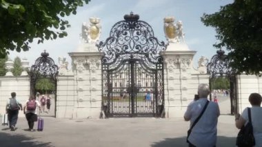 Viyana, Avusturya - 18 Temmuz 2024: Turistler Viyana 'daki Belvedere Sarayı bahçesinin zarif demirden kapılarının fotoğraflarını çekiyorlar..